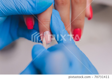 woman doing manicure in a beauty salon. Close-up of hands. 70731411