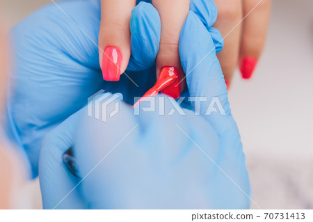 woman doing manicure in a beauty salon. Close-up of hands. 70731413