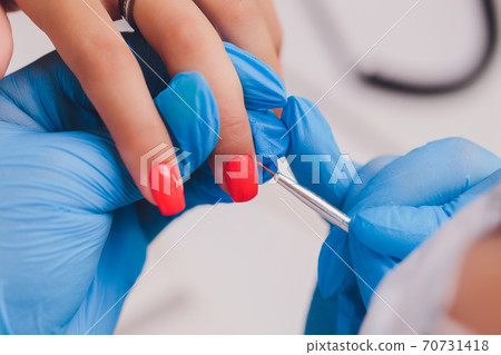 woman doing manicure in a beauty salon. Close-up of hands. 70731418
