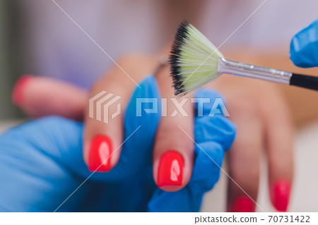 woman doing manicure in a beauty salon. Close-up of hands. 70731422