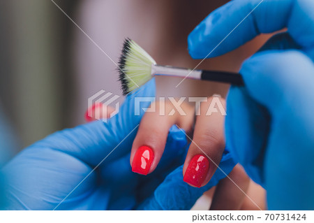 woman doing manicure in a beauty salon. Close-up of hands. 70731424
