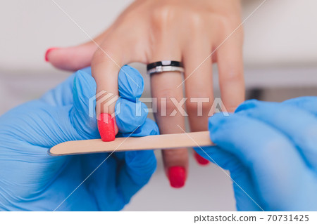 woman doing manicure in a beauty salon. Close-up of hands. 70731425