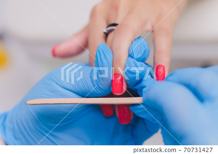 woman doing manicure in a beauty salon. Close-up of hands. 70731427