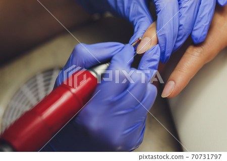 woman doing manicure in a beauty salon. Close-up of hands. 70731797