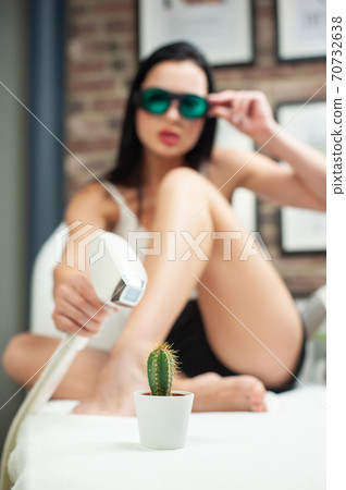 a woman in a laser hair removal Studio poses with a cactus shallow depth of field a woman in a laser hair removal Studio poses with a cactus shallow depth of field 70732638