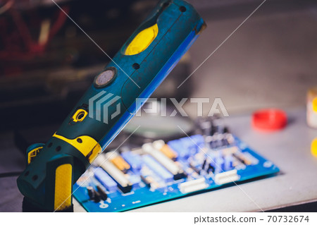 Closeup on electronic board in hardware repair shop, blurred and toned image. Shallow DOF, focus on the middle left field. Closeup on electronic board in hardware repair shop, blurred and toned image. Shallow DOF, focus on the middle left field. 70732674