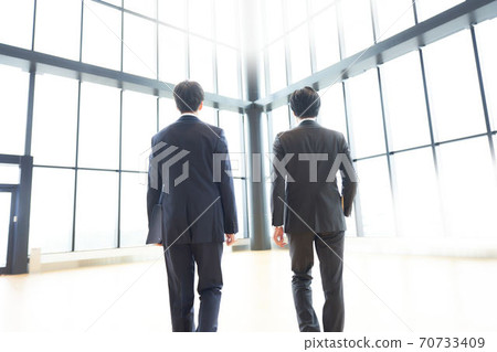 Rear view of a walking businessman Rear view of a walking businessman 70733409