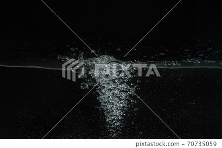 Water splashing as it's poured into aquarium tank, black background Water splashing as it's poured into aquarium tank, black background 70735059