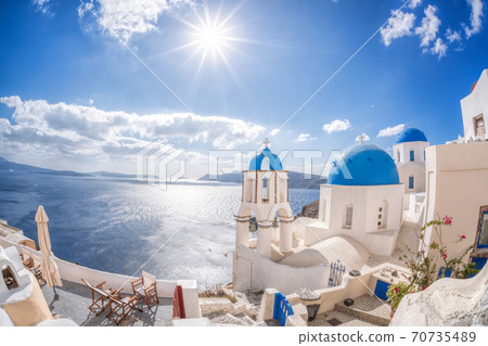 Oia village with churches against azure sea on Santorini island in Greece 70735489