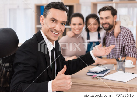 Realtor in a suit shows thumb up. Realtor in a suit shows thumb up. 70735510