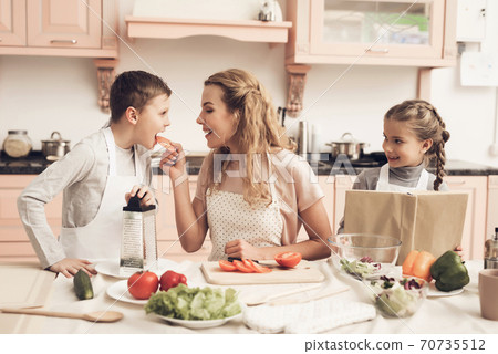 Children with mother at kitchen table in kitchen. Children with mother at kitchen table in kitchen. 70735512