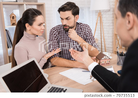 The girl shows the guy who is sitting at the table The girl shows the guy who is sitting at the table 70735513