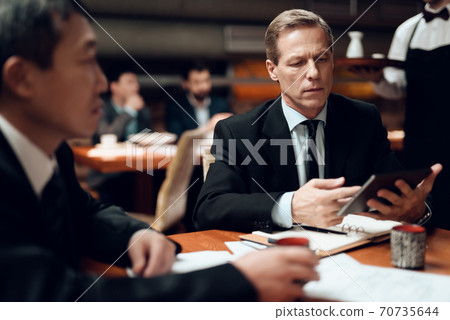 Waiter brings food to business people. Waiter brings food to business people. 70735644