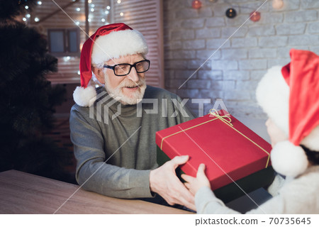 Grandfather gives grandson a box with a gift. 70735645