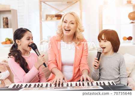 Grandmother with grandchildren singing.  70735646