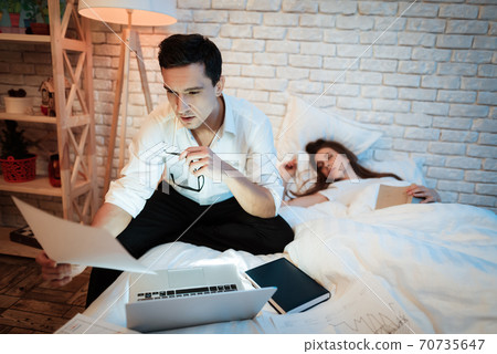 Young businessman is studying graphics on laptop. Young businessman is studying graphics on laptop. 70735647