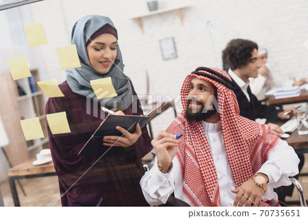 Disabled arab man in wheelchair working in office. Disabled arab man in wheelchair working in office. 70735651