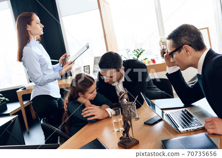 Dad and daughter sit at the table at the lawyer. Dad and daughter sit at the table at the lawyer. 70735656