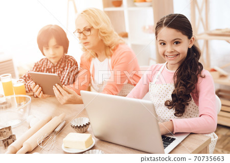 A young girl sits in the kitchen and plays. A young girl sits in the kitchen and plays. 70735663