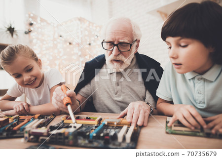 Grandpa teaches children how to braze. Grandpa teaches children how to braze. 70735679