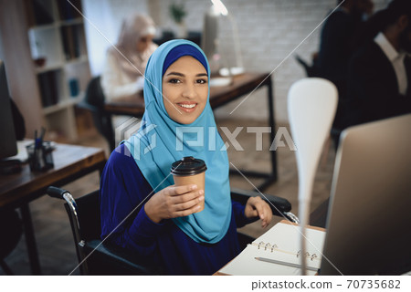 Arab girl sits at a table and drinks coffee. Arab girl sits at a table and drinks coffee. 70735682