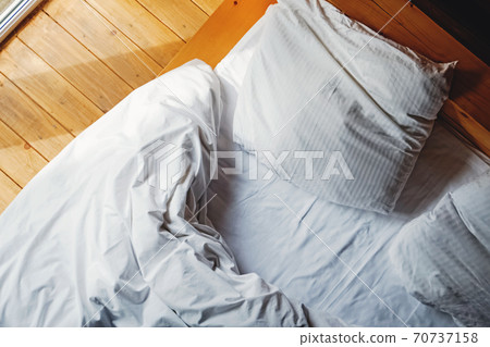 Bed and pillows with white bedsheet in the sunny room 70737158