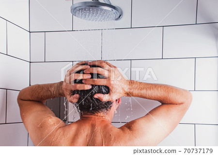Back of a man taking a shower and washing his head 70737179
