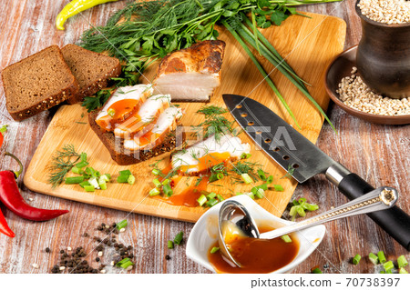 smoked meat lies on the table with herbs and sauce 70738397