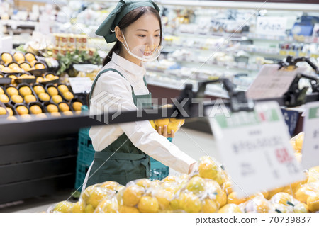 A female employee with a mouse shield doing inventory at a supermarket 70739837
