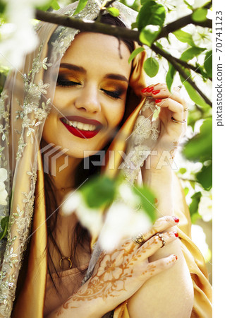young pretty indian girl in jewelry and veil posing cheerful happy smiling in green park, lifestyle people concept young pretty indian girl in jewelry and veil posing cheerful happy smiling in green park, lifestyle people concept 70741123