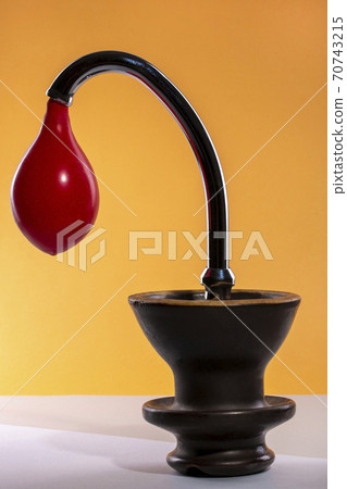 Vase with a balloon in a water tap on a colored background Vase with a balloon in a water tap on a colored background 70743215