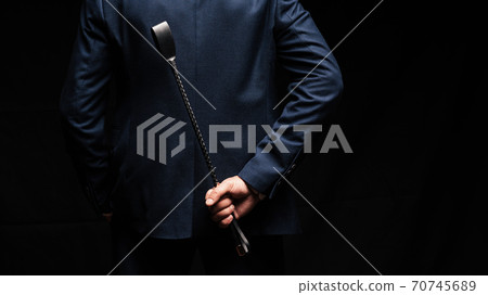 male dominant holds a leather whip Flogger for hard BDSM sex 70745689