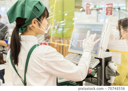 A woman paying at a supermarket cashier A woman paying at a supermarket cashier 70748556