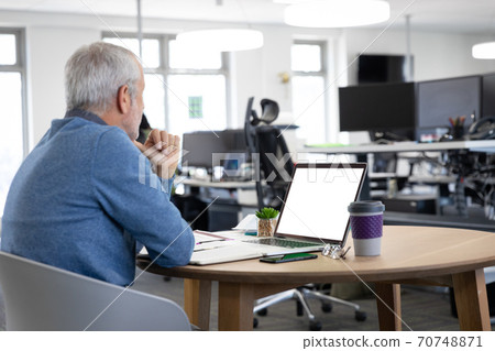 Senior businessman using laptop at modern office 70748871