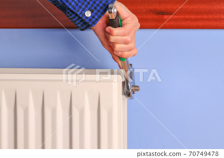 Hand of a man, repairman, installation repair radiator valve closeup 70749478