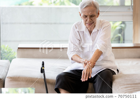 Old elderly patient suffer from gout,rheumatoid,chronic arthritis with severe pain,injury wrist bones,Asian senior woman is rubbing and massaging her wrist,beriberi in hands or numbness of the fingers Old elderly patient suffer from gout,rheumatoid,chronic arthritis with severe pain,injury wrist bones,Asian senior woman is rubbing and massaging her wrist,beriberi in hands or numbness of the fingers 70750111