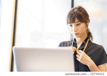 在在線會議開始之前正在檢查屏幕上衣服外觀的業務人員 在在線會議開始之前正在檢查屏幕上衣服外觀的業務人員 70750422