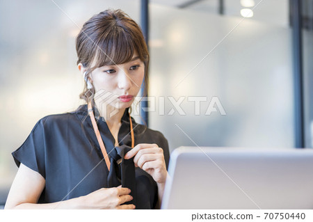 A business person who is rechecking how his clothes are reflected on the screen before the start of an online meeting. A business person who is rechecking how his clothes are reflected on the screen before the start of an online meeting. 70750440