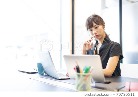 Business person who operates a personal computer and a tablet and works 70750511