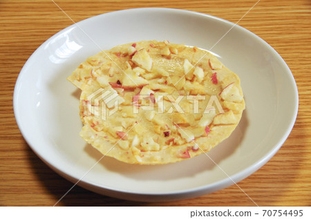 一個烤的南部的米糕的照片用蘋果灑在放置在一塊白色板材和安置的麵團在木五穀桌上。 一個烤的南部的米糕的照片用蘋果灑在放置在一塊白色板材和安置的麵團在木五穀桌上。 70754495