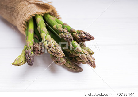 Bunch of fresh green asparagus on white table Bunch of fresh green asparagus on white table 70755444