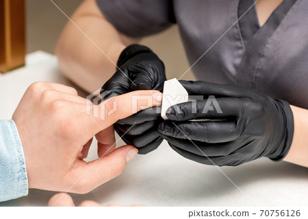 Manicurist doing manicure by nail file Manicurist doing manicure by nail file 70756126