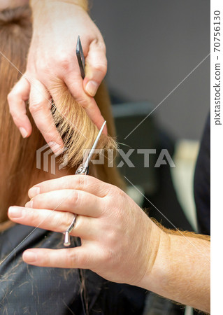 Hairdresser cuts hair to young woman Hairdresser cuts hair to young woman 70756130