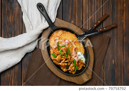 Cast iron skillet with potato pancakes and fried chanterelles Cast iron skillet with potato pancakes and fried chanterelles 70758702
