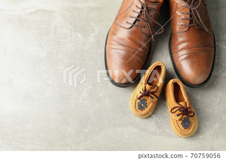 Brown leather shoes and children's shoes on grey background 70759056