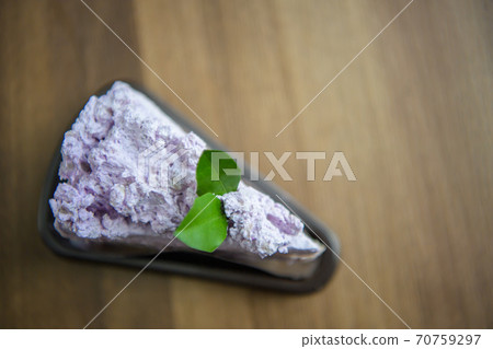 Taro flavor cake on the table in cafe. 70759297