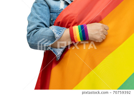 Asian lady wearing blue jean jacket or denim shirt and holding rainbow color flag, symbol of LGBT pride month celebrate annual in June social of gay, lesbian, gay, bisexual, transgender, human rights. 70759392