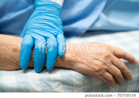 Asian doctor wearing globe to check  patient protect safety infection Covid-19 Coronavirus outbreak at quarantine nursing hospital ward. 70759539