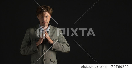 Confident businessman or scientist looks forward with folded fingers. Cut out on black background. Copy spase at right side Confident businessman or scientist looks forward with folded fingers. Cut out on black background. Copy spase at right side 70760233