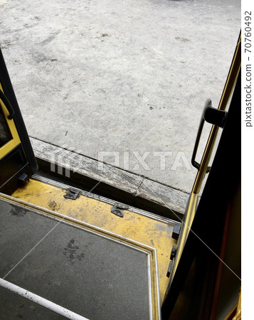 The level of the surface between the curb of a public transport stop and the open door platform of a bus approaching. The level of the surface between the curb of a public transport stop and the open door platform of a bus approaching. 70760492
